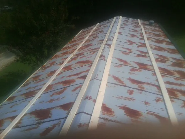 Rusted metal roof panels with new wood purlins before replacement — Storm Damage Roof Repair in Straughn by Roofing Brothers